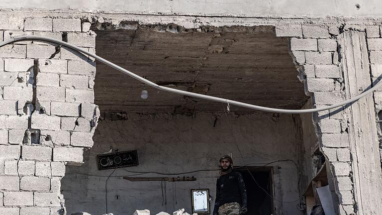 Nahostkonflikt - Aleppo       -  Ein Mann steht nach einem Luftangriff auf die Stadt Atarib in der Umgebung von Aleppo in einem zerstörten Gebäude. (Archivbild)