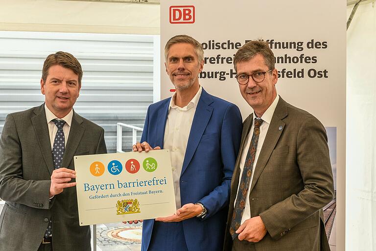 Der Bahnhof Heidingsfeld Ost wurde offiziell eröffnet und als barrierefrei ausgezeichnet. Der Staatssekretär im Bayerischen Staatsministerium des Innern, für Sport und Integration, Sandro Kirchner (links), überreicht im Beisein von Oberbürgermeister Christian Schuchardt (rechts) das Signet 'Bayern barrierefrei' an Andreas Rudolf, Leiter Regionalbereich Süd der DB Station&Service AG. Der Bahnhof Heidingsfeld Ost wurde offiziell eröffnet und als barrierefrei ausgezeichnet. Der Staatssekretär im Bayerischen Staatsministerium des Innern, für Sport und Integration, Sandro Kirchner (links), überreicht im Beisein von Oberbürgermeister Christian Schuchardt (rechts) das Signet 'Bayern barrierefrei' an Andreas Rudolf, Leiter Regionalbereich Süd der DB Station&Service AG.