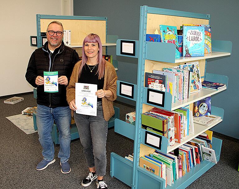 Schulleiter Philipp Arnold und Lehrerin Saskia Hofmann präsentieren das Gütesiegel 'Treffpunkt Schulbibliothek'. Schulleiter Philipp Arnold und Lehrerin Saskia Hofmann präsentieren das Gütesiegel 'Treffpunkt Schulbibliothek'.