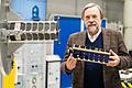 Prof. Klaus Schilling, Inhaber des Lehrstuhls für Robotik und Telematik an der Uni Würzburg, mit einem Satelliten aus der NetSat-Reihe. Vier von ihnen umkreisen derzeit in 600 Kilometern Höhe die Erde.