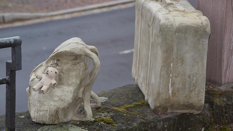 Ein Kinderrucksack und ein Koffer auf der Mauer an der Plattnersgasse in Gemünden, gestaltet aus Beton, erinnern an die Deportationen der Juden. Ein Kinderrucksack und ein Koffer auf der Mauer an der Plattnersgasse in Gemünden, gestaltet aus Beton, erinnern an die Deportationen der Juden.