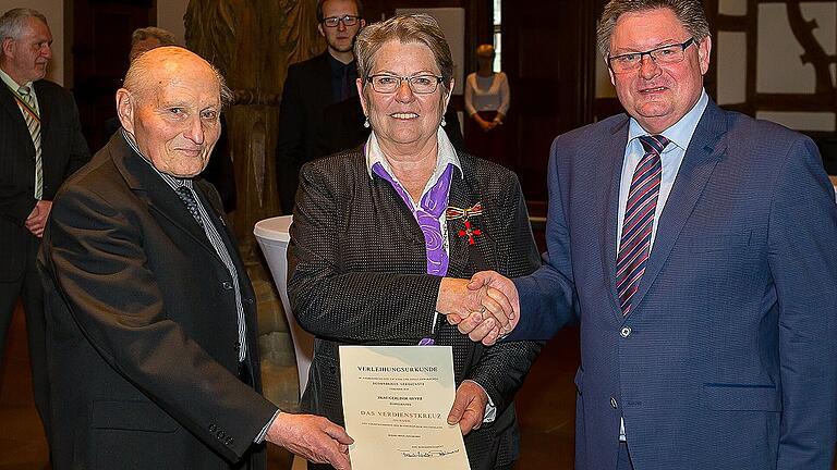 Ehrung on der Rathausdiele. Das Bundesverdienstkreuz am Band erhielt Gerlinde Geyer. Links Monsignore Emil Heßdörfer, rechts Staatssekretär Gerhard Eck.