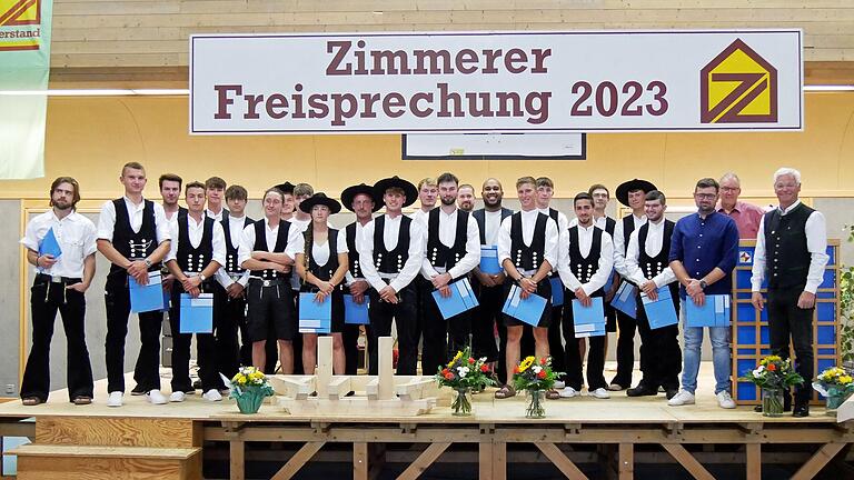 Bei der Freisprechung der Zimmerergesellen in der Innung Würzburg-Kitzingen. Von links: Jannik Foydl, Leonhard Gattenlöhner, Louis Birk, Leonard Freitag, Marlon Blum, Oliver Haaf, Noah Kahl, David Dittmann, Christoph Kühn, Lotta Fabisch, Hans Pfannes, Riko Georgi, Krishna Kraiss, Laurenz Link, Sven Rexhausen, Pablo Tabares, Innungssieger Julian Maier, Max Herbig-Ungemach, Christian Mack, Marc Klapper, Lukas Pöhlmann, Felix Keller, Stellvertretender Obermeister Sebastian Rappelt, Obermeister und Vizepräsident des Bayerischen Zimmererverbandes Hermann Lang und Präsident des Bayerischen Zimmererverbandes Peter Aicher.