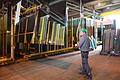 Glaskeil in Würzburg: Ein Arbeiter transportiert das an den Kran angesaugte Spiegelglas aus dem Glasregal zur Schneidemaschine.