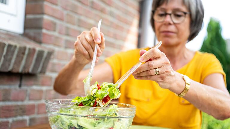 Eine Frau ist Salat       -  Frisch und lecker: Ein Salat ist an heißen Tagen genau das Richtige.