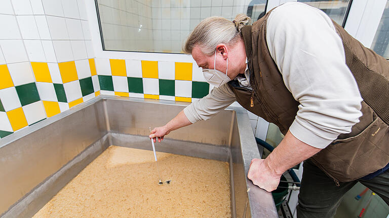Sorgfältig prüft der Brauer die Temperatur des Suds. Sorgfältig prüft der Brauer die Temperatur des Suds.