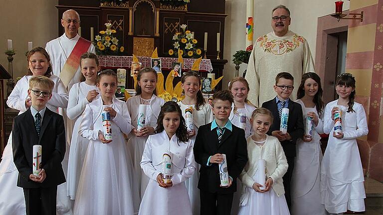 Mädchen und Buben feierten in Bieberehren das Fest der Kommunion       -  (ela)   Ministranten mit Fahnen und die Trachtenkapelle holten die Kommunionkinder und ihre Eltern am Haus der Vereine in Biberehren ab und begleiteten sie in die festlich geschmückte, voll besetzte Kirche St. Peter und Paul. Das Thema der diesjährigen Kommunion war &bdquo;Du hast uns einen Schatz geschenkt&ldquo;, heißt es in einer Mitteilung. Pauline Hobmaier, Leni Nast, Johannes Rein, Niklas Roth, Amelie-Sophie Schenk, Selina Spiegel und Jana Sturm, aus Bieberehren, Alina Haas, aus Buch, Inka und Fynn Eichinger und Thea Lochner aus Röttingen, Nora Haag aus Strüth und Heidi Pflüger aus Tauberrettersheim erhielten in einem festlichen Gottesdienst erstmals die Heilige Kommunion. Pfarrer Gerhard Hanft feierte die Messe mit Diakon Winfried Langlouis, der auch die lange Vorbereitung der Kinder begleitete. Die musikalische Gestaltung übernahmen Andreas Gloos (Orgel) und die &bdquo;Hermann-Singers&ldquo; (Leitung: Hermann Vogel).