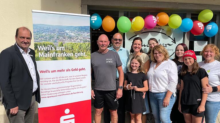 Vor dem 'tauschbar' in der Bahnhofstraße 5a in Reichenberg (von links): Peter Markert (Sparkasse Mainfranken), Rüdiger Krauß (Fa. Renos, Fuchsstadt), Stefan Hemmerich (1. Bürgermeister des Marktes Reichenberg), einige Ehrenamtliche des Teams tauschbar (auch die Kinder helfen hier immer wieder fleißig mit)