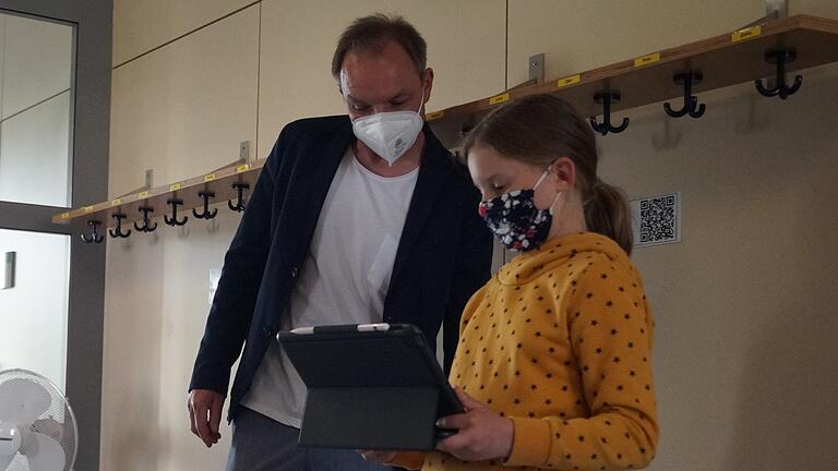 Lesespur: An der Wand im Gang des Schulhauses hängen QR-Codes, die es Emily Scheck erlauben, eine Geschichte zu lesen. Das findet auch Bürgermeister Matthias Schneider sehr interessant. Lesespur: An der Wand im Gang des Schulhauses hängen QR-Codes, die es Emily Scheck erlauben, eine Geschichte zu lesen. Das findet auch Bürgermeister Matthias Schneider sehr interessant.