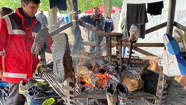 Wo normalerweise Bratwürste auf dem Grill liegen, werden beim Zeltlager in Sulzfeld Schuhe und Kleidung am offene Feuer getrocknet.