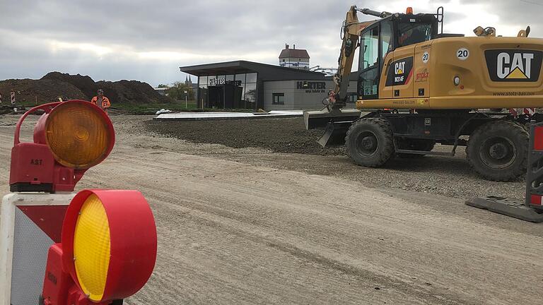 Der Bau des Linksabbiegers für das Industriegebiet an der Mönchstockheimer Straße schreitet voran. Der Fahrbahnteiler (weiße Steine) vor dem Firmengelände der Firma Harter ist schon fertiggestellt.