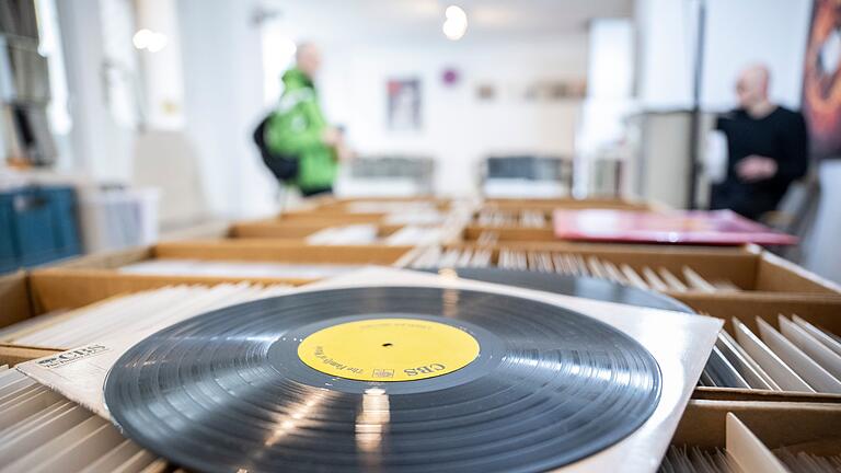 Schallplatte liegt auf einer Box mit weiteren Tonträgern - Stark nachgefragte Originalpressung? Das erkennt man unter anderem an Nummern, Signaturen oder Kürzeln auf der Innenrille der Platte. Schallplatte liegt auf einer Box mit weiteren Tonträgern - Stark nachgefragte Originalpressung? Das erkennt man unter anderem an Nummern, Signaturen oder Kürzeln auf der Innenrille der Platte.