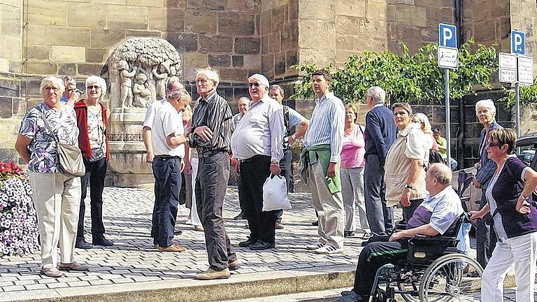 Ausflug nach Ansbach: Interessiert folgen Turnhouter und Hammelburger den Ausführungen des Gästeführers vor der Kirche St. Gumbertus.