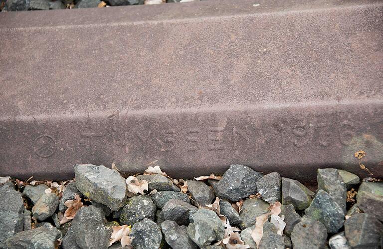 Auf der Eisenbahnstrecke von Schweinfurt über Gerolzhofen nach Kitzingen sind sie noch anzutreffen: Eisenbahnschwellen aus Stahl. Sie tragen die historischen Walzzeichen der Firmen, die sie einst herstellten. Was Rang und Namen hatte in der deutschen Montanindustrie, kann anhand der Eisenbahnschwellen nachvollzogen werden, so zum Beispiel die Firmen Thyssen (Foto) und Krupp. Auf der Eisenbahnstrecke von Schweinfurt über Gerolzhofen nach Kitzingen sind sie noch anzutreffen: Eisenbahnschwellen aus Stahl. Sie tragen die historischen Walzzeichen der Firmen, die sie einst herstellten. Was Rang und Namen hatte in der deutschen Montanindustrie, kann anhand der Eisenbahnschwellen nachvollzogen werden, so zum Beispiel die Firmen Thyssen (Foto) und Krupp.