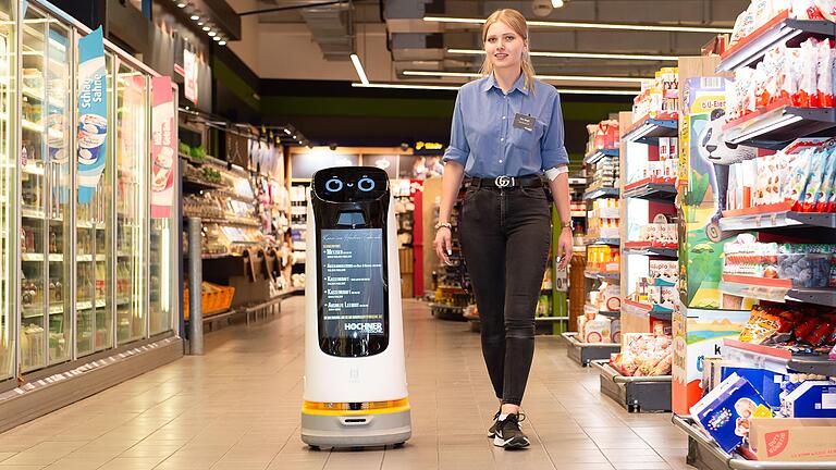 Seit Kurzem hat der Edeka-Markt Höchner in Schweinfurt eine neue Mitarbeiterin: Roboter Berta hilft jetzt beim Einkaufen. Mitarbeiterin Jessica Werger begleitet Berta zu ihrer Schicht. Seit Kurzem hat der Edeka-Markt Höchner in Schweinfurt eine neue Mitarbeiterin: Roboter Berta hilft jetzt beim Einkaufen. Mitarbeiterin Jessica Werger begleitet Berta zu ihrer Schicht.