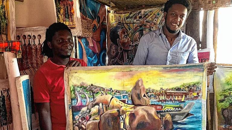 Mwanza aus geografischer und sozialökonomischer Perspektive zeigt das Bild von Biggety Mushidi, welches Mejah Salimu (31, links) und Isack Asfao (27) in ihrer African Art Gallery präsentieren: 'Der Bismarck Rock als das Wahrzeichen Mwanzas symbolisiert die Stadt und die Kamanga-Fähre steht für die sozialökonomischen Aktivitäten' erklärt Asfao die Intention des Malers. Mwanza aus geografischer und sozialökonomischer Perspektive zeigt das Bild von Biggety Mushidi, welches Mejah Salimu (31, links) und Isack Asfao (27) in ihrer African Art Gallery präsentieren: 'Der Bismarck Rock als das Wahrzeichen Mwanzas symbolisiert die Stadt und die Kamanga-Fähre steht für die sozialökonomischen Aktivitäten' erklärt Asfao die Intention des Malers.
