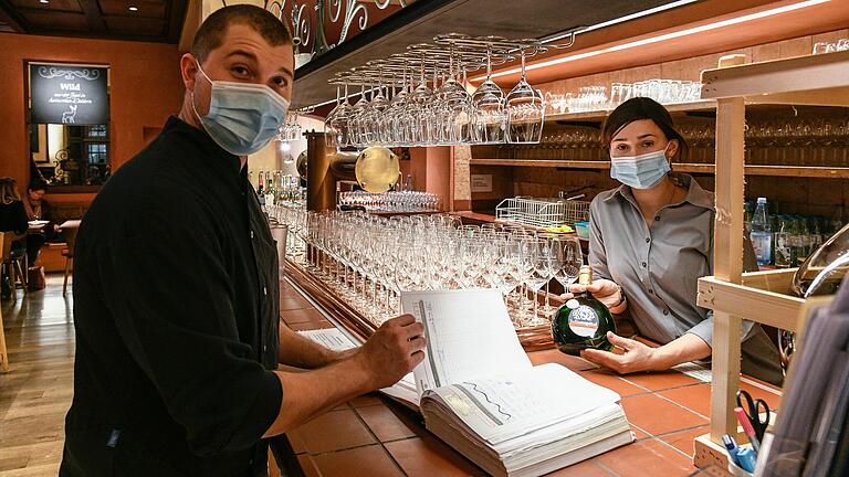 Ein sorgenvoller Blick ins Reservierungsbuch. Viele Weihnachtsfeiern wurden auch in den Juliusspital Weinstuben bei Christina Keltsch und Lukas Kulinna (Foto) abgesagt. Seniorchef Frank Kulinna beklagt im Gespräch das 'Hü und Hott' der Politik.