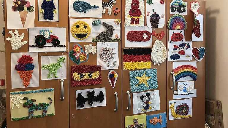 Die Klienten von Annemarie Gräbner drehen kleine Papierkügelchen, um die Fingerfertigkeit zu trainieren. Mit den Kügelchen gestalten sie Bilder.