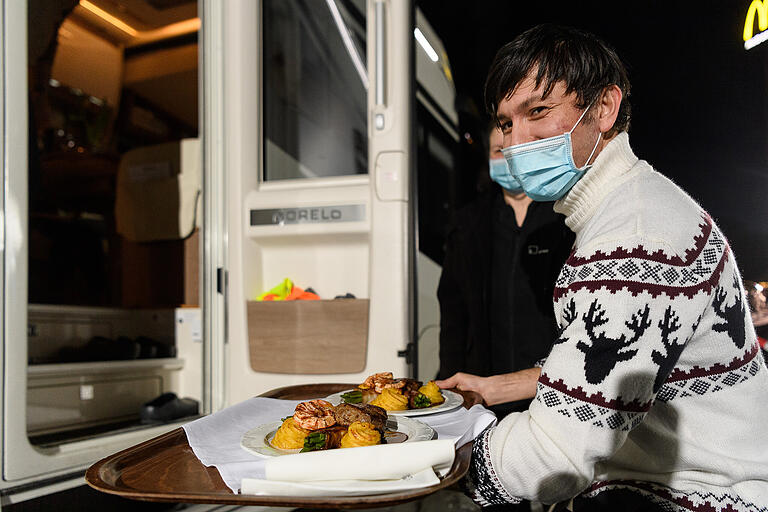 Auszubildende und Mitarbeiter servieren am Abend des Valentinstags vor dem Restaurant des Autohofs in Geiselwind Abendessen – direkt an die Autos und Wohnmobile. Auszubildende und Mitarbeiter servieren am Abend des Valentinstags vor dem Restaurant des Autohofs in Geiselwind Abendessen – direkt an die Autos und Wohnmobile.