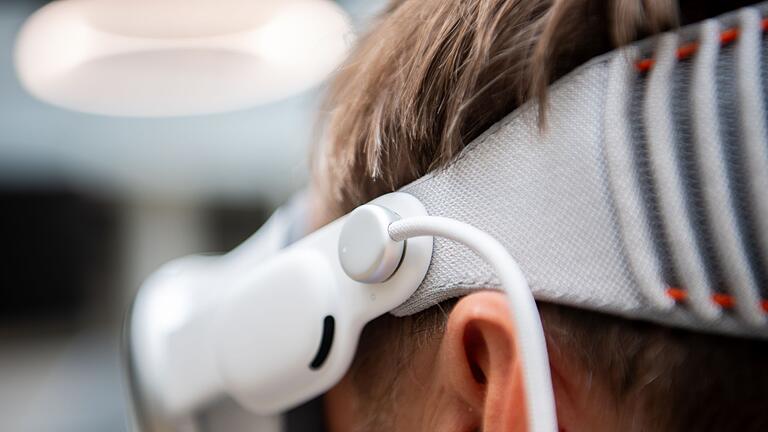 Der Anschluss für den externen Akku der Vision Pro       -  Damit die Brille leichter auf dem Kopf sitzt, hat Apple den Akku ausgelagert. Hier ist die Anschlussstelle zu sehen. Links daneben sitzt einer der beiden Lautsprecher.