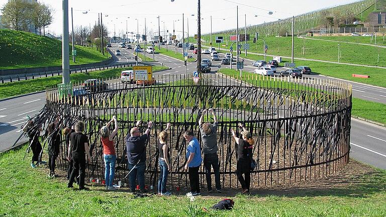 Aktivisten befestigen Trauerflor an den Gitterstäben des zerstörten &bdquo;Sanctuariums&rdquo; von herman de vries in Stuttgart.