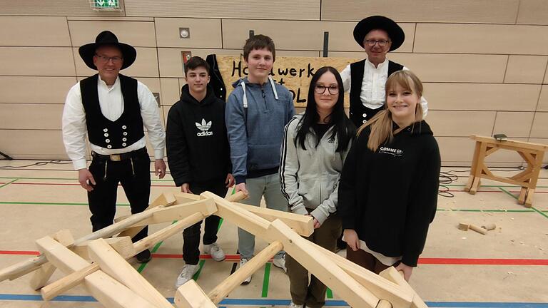 Applaus für Lennox, Niklas, Shanice und Anastasia (von links), die ihr Holzbau-Talent an der Da-Vinci-Brücke zeigten. Innungsobermeister Hermann Lang und Richard Betz mit seinem Theaterstück 'Hand und Werk' hatten in der Mittelschule in Ochenfurt speziell für den Holzbau und das Handwerk allgemein geworben. Applaus für Lennox, Niklas, Shanice und Anastasia (von links), die ihr Holzbau-Talent an der Da-Vinci-Brücke zeigten. Innungsobermeister Hermann Lang und Richard Betz mit seinem Theaterstück 'Hand und Werk' hatten in der Mittelschule in Ochenfurt speziell für den Holzbau und das Handwerk allgemein geworben.