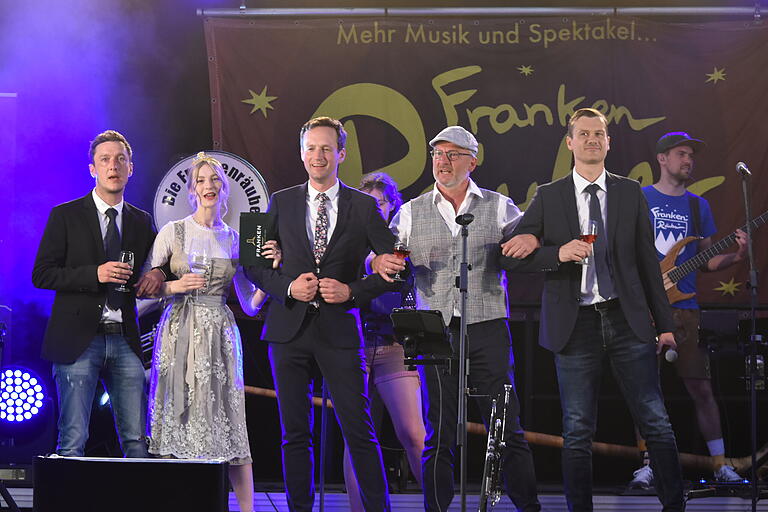 Musik und Wein gab's bei der Eröffnung des Donnersdorfer Weinfestes. Im Bild (von links) Felix Schorr (1. Vorsitzender des Vereins Heimat & Wein), Weinprinzessin Emily I., Landrat Florian Töpper, Bürgermeister Klaus Schenk und Stefan Meißner (Vorsitzender FC Blau-Weiß Donnersdorf). Musik und Wein gab's bei der Eröffnung des Donnersdorfer Weinfestes. Im Bild (von links) Felix Schorr (1. Vorsitzender des Vereins Heimat & Wein), Weinprinzessin Emily I., Landrat Florian Töpper, Bürgermeister Klaus Schenk und Stefan Meißner (Vorsitzender FC Blau-Weiß Donnersdorf).