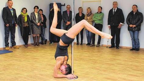 Technik, Kraft und Ästhetik: Der Pole Dance hat sein Rotlicht-Image abgelegt, will als Sportart nun gar olympisch werden. Im an diesem Freitag in der Jahnstraße öffnenden Fitness-Box-Camp wird es neben vielem anderem auch Pole-Dance-Kurse geben. Das Bild entstand beim Vorab-Rundgang mit Betreiber Sven Amend (links) und Immobilienbesitzer Wilhelm Ciufrida (Zweiter von rechts). Die Besucher bestaunen die Vorführung von Anna Herold.