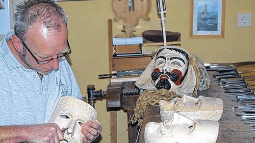 Filigrane Arbeit: Der Oberelsbacher Holzbildhauer Franz Weigand schnitzt Masken aus Traditionsbewusstsein. Die von seinem Vater hergestellte Maske im Hintergrund dient dabei als Modell.