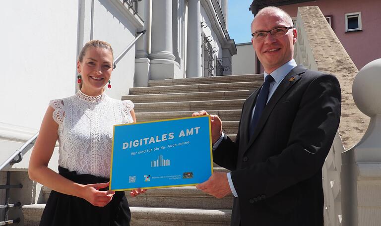 Das Schild soll Werbung machen für die digitalen Verwaltungsleistungen: Judith Gerlach übergibt die Auszeichnung an Iphofens Bürgermeister Dieter Lenzer.