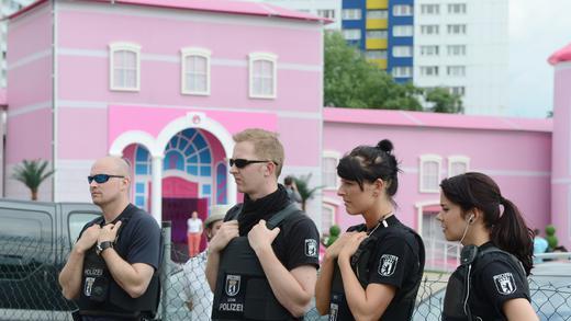 Proteste gegen Barbie-Haus       -  Polizisten sichern am 16.05.2013 in Berlin am Alexanderplatz das &quot;Barbie Dreamhouse&quot; am Eröffnungstag, nachdem es durch Proteste zu Zwischenfällen gekommen ist. Die Erlebniswelt auf 2.500 Quadratmetern ist drei Monate in der Hauptstadt zu sehen. Foto: Jens Kalaene/dpa +++(c) dpa - Bildfunk+++