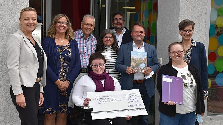 Geimpft, genesen, getestet und glücklich über den Gewinn: Christine Hildebrand (BKK Diakonie), Elke Krug (Leiterin soziale Fachdienste), der langjährige Einrichtungsleiter Reinhold Stiller, Katharina Moser (Projektgruppe - mit Scheck), Anna Carina Fries (Projektgruppe), OBA-Leiter Uwe Klein, Markus Koch (VRK), Irmgard Hetterich (Projektgruppe) und die Vorsitzende der Diakonie Bayern, Sandra Schuhmann, (von links) freuten sich über den Sieg der Schweinfurter im bayernweiten Wettbewerb.