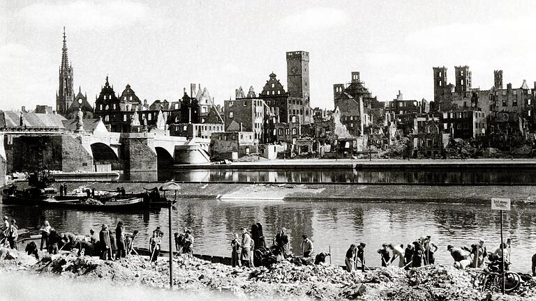 Die historische schwarz-weiß Aufnahme zeigt Würzburger Frauen und Männer im Jahr 1946 nach der Bombardierung Würzburgs bei der Trümmerräumung. Kurz vor dem Ende des Zweiten Weltkriegs am 16. März 1945 zerstören Alliierte das mittelalterliche Würzburg. Die historische schwarz-weiß Aufnahme zeigt Würzburger Frauen und Männer im Jahr 1946 nach der Bombardierung Würzburgs bei der Trümmerräumung. Kurz vor dem Ende des Zweiten Weltkriegs am 16. März 1945 zerstören Alliierte das mittelalterliche Würzburg.