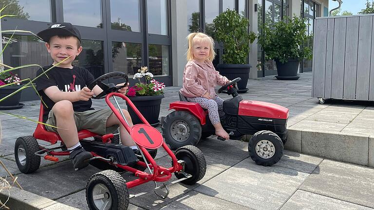 Im Hof der Gaststätte 'Gräfners Fuhrwerk' in Sommerach haben Kinder –&nbsp;wie hier Julius und Paula – viel Platz, um mit den Kinderfahrzeugen zu fahren.&nbsp;