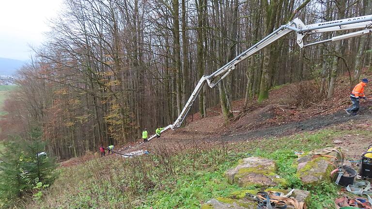 Der lange Kragarm der Betonpumpe wird mit vier Meter langen Schlauchstücken verlängert, bis er zur Betonierstelle reicht. Die Arbeiten am Steilhang sind trotz Spezeialfahrzeugen sehr mühsam.