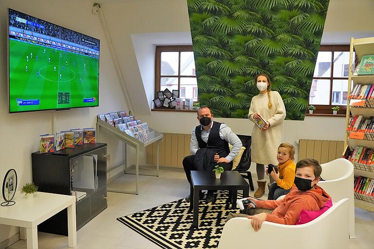Die neue Biblounge im Obergeschoss der Bücherei bietet Spaß, Abwechslung und die Förderung der Medienkompetenz. Im Bild Bürgermeister Christian Keller, Bibliotheksleiterin Anna Scharf, sowie Oskar und Moritz, die die neue Playstation einweihen durften.