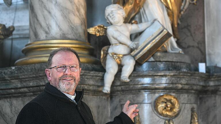 Wo jeder Engel einen eigenen Charakter hat: Pfarrer Treutlein vor einem Exemplar, das in einem großen Buch blättert. Auch für seine Sanierung wurde eine Patenschaft übernommen. Wo jeder Engel einen eigenen Charakter hat: Pfarrer Treutlein vor einem Exemplar, das in einem großen Buch blättert. Auch für seine Sanierung wurde eine Patenschaft übernommen.