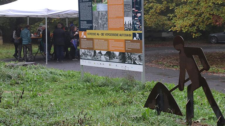 Großformatige Informationstafeln, weitere Tafeln mit Wegebeschreibungen und der metallene Straßenarbeiter stehen an den wichtigen Ausgangspunkten für die 'Strecke 46 –&nbsp;Auf Spurensuche', hier am 'Rhönblick' zwischen Gräfendorf und Burgsinn.