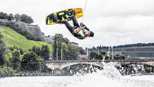 Gute Bedingungen für Wakeboarder beim Wettbewerb in Würzburg       -  (jha)  Sommergefühl kam nicht auf, aber ein paar Regenschauer konnten der Veranstaltung am Würzburger Stadtstrand wenig anhaben: Das Sternla WakeRace, ein Wakeboard-Wettbewerb mit sieben der besten Fahrer Deutschlands, startete am Sonntag in einen Vormittag vor dunkler Wolkenkulisse, die Badeklamotten aus der Modenschau blieben nicht trocken. Am Nachmittag blieb der Stadtstrand jedoch großteils trocken, so dass bis 15 Uhr laut Veranstalter rund 6000 Zuschauer vorbeikamen. Der Akrobat Moritz Haase beendete seine Tuch-Showeinlage an einem Kranhaken in vier Metern Höhe über dem Main mit einem Sprung ins Wasser. &bdquo;Regen wäre nicht schlimm gewesen, aber der Wind hat mir das Tuch um Gelenke und Gesicht gewickelt&ldquo;, sagte er später. Der Wind wehte zwar, die Wasseroberfläche blieb jedoch glatt &ndash; gute Bedingungen also für Wakeboarder. Stürze blieben bei den anspruchsvollen Tricks trotzdem nicht aus. Nur vereinzelte Hobbyboote verirrten sich während der zeitweiligen Schifffahrtssperre in den 400-Meter-Bereich vorm Stadtstrand. Live-Blog mit Videos zum Nachlesen und viele Fotos von der Veranstaltung finden sie unter www.mainpost.de/sternla-wakerace