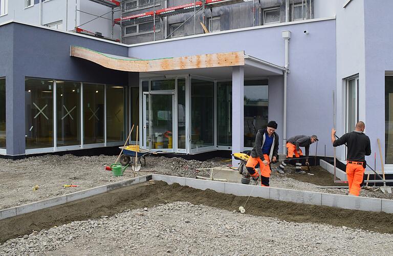 Letzte Arbeiten am neuen Bad Königshöfer Gesundheitszentrum: Mitarbeiter der Baufirma SST mit Sitz in Salz  bereiten das Pflastern des Eingangsbereiches vor.