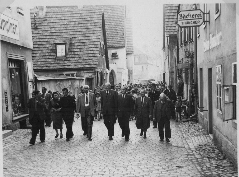 Am 26. Mai 1955 besuchte der damalige Bundespräsident Theodor Heuß Gerolzhofen. Man spazierte auch am Fachwerkhaus Hümpfner (links) vorbei. Hinter dem Mäuerchen verbarg sich ein kleiner Garten, der später dann mit der neuen Werkstatt überbaut wurde.