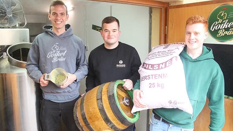 Die drei angehenden Brauer Johannes Marschall, Veit Pfeuffer-Martin und Jerome Wappes (von links) haben in der Halsbacher Goikelbräu ihren zuvor im Rahmen der Gesellenprüfung in Kleinstmenge angesetzten Gesellensud nachgebraut. Das Bild zeigt sie mit Hopfenpellets, Bierfass und Malz-Sack.