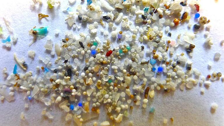 Mikroplastik       -  Mikroplastikkügelchen auf einem Blatt Papier. Die kleinen Plastikteilchen mit einer Größe unter fünf Millimetern verschmutzen die Meere und werden oft von Fischen und anderen Meeresbewohnern aufgenommen.