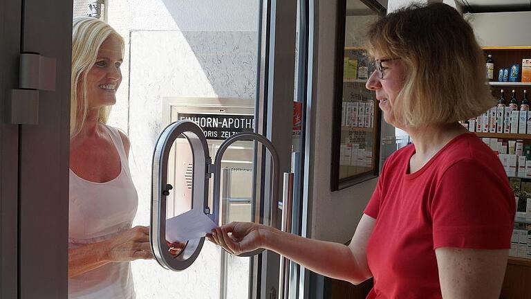 Apothekerin Doris Zeltner (rechts) nimmt von einer Patientin ein Rezept durch die Notdienstklappe entgegen. Bisher ist in Haßfurt immer in mindestens einer Apotheke die Versorgung gewährleistet. Das könnte sich jedoch bald ändern.