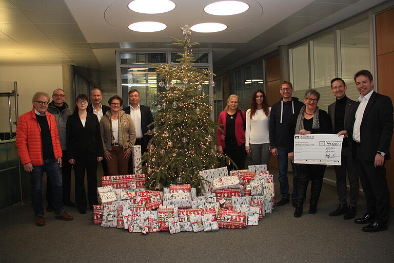 Das Bild zeigt die Übergabe der Wunschbaum-Geschenke in der VR-MainBank mit (von links) Stefan Labus (Kindertafel Schweinfurt), Pastoralreferent Josef Pohli, Bankdirektorin Jutta Ackermann, Bankdirektor Klaus Henneberger, Elisabeth Orth (Gerolzhofen-aktiv), Bankdirektor Franz-Josef Hartlieb, Gertrud Wiederer (Offene Ganztagsschule Kolitzheim), Eva-Maria Hoffart, Gerald Möhrlein (beide Erich-Kästner-Kinderdorf Oberschwarzach), Irene Schmitt (Gerolzhofen-aktiv), Bürgermeister Thorsten Wozniak und Bankdirektor Thomas Endres.