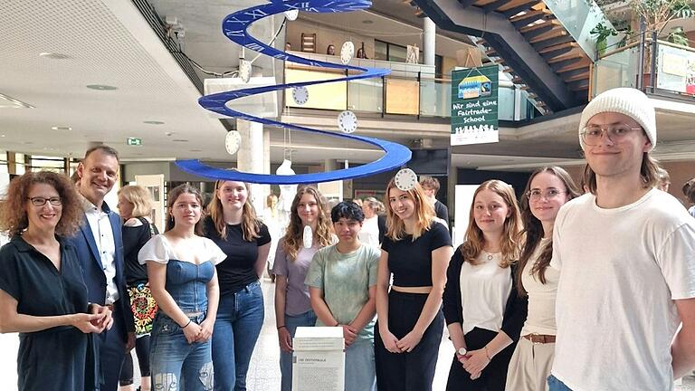 Foto von den Ausstellenden des W-Seminars des Gymnasiums Veitshöchheim in der Schulaula (von links): Kunstlehrerin Berit Holzner, Schulleiter Bernhard Brunner, Josepha Berger, Annika Rau, Jonna Drexlmaier, Anna Popp, Camila Valencia, Maren Maurer, Lena Gerstner und Julian Mensch.