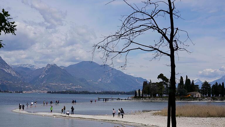 Trockenheit in Italien.jpeg - Touristen gehen über einen Streifen Land zwischen dem Festland und der Insel San Biagio. Trockenheit in Italien.jpeg - Touristen gehen über einen Streifen Land zwischen dem Festland und der Insel San Biagio.