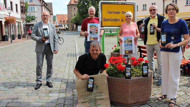 Die Steuerungsgruppe Fair-Trade stellt die neue Designs des Stadtkaffees vor. Im Bild (von links) Bürgermeister Jürgen Lippert, Wolfgang Fella (alle Weltladen und Stadtmarketing), Doris Betz, Dieter Konradt, Elke Herkert-Mai und Ralf Obert (vorne knieend).