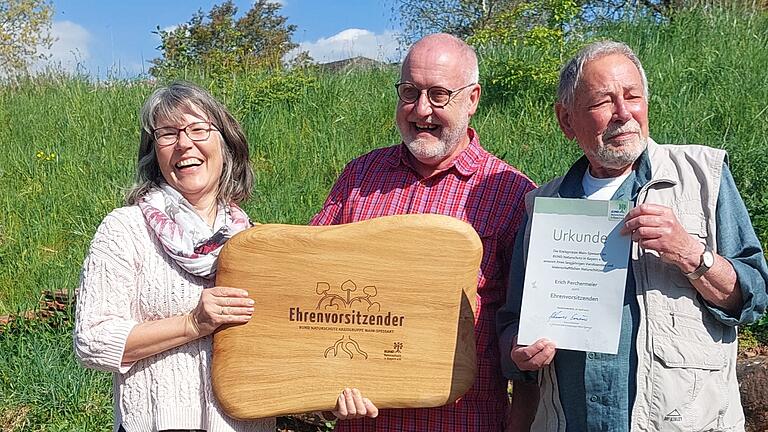 Conni Schlosser und Erwin Scheiner überreichen Erich Perchermeier (von links) Urkunde und Holztafel.
