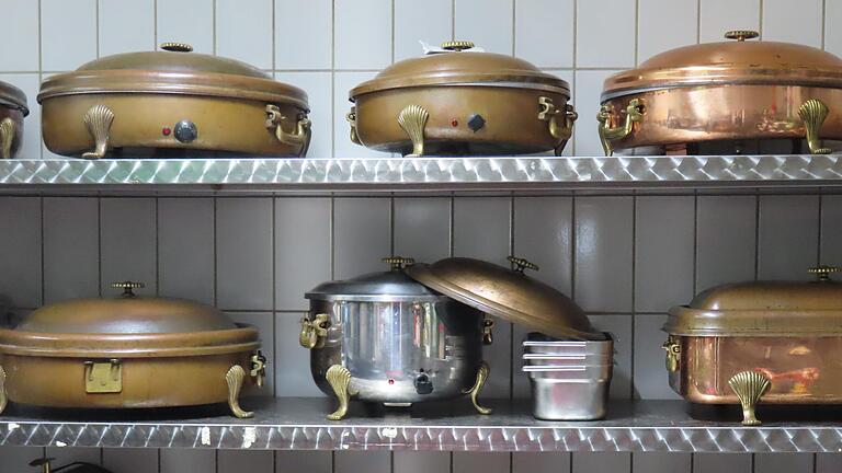 In einem Nebenraum sind die Transport- und Warmhaltegefäße fürs Catering sorgsam in die Regale eingereiht. In einem Nebenraum sind die Transport- und Warmhaltegefäße fürs Catering sorgsam in die Regale eingereiht.